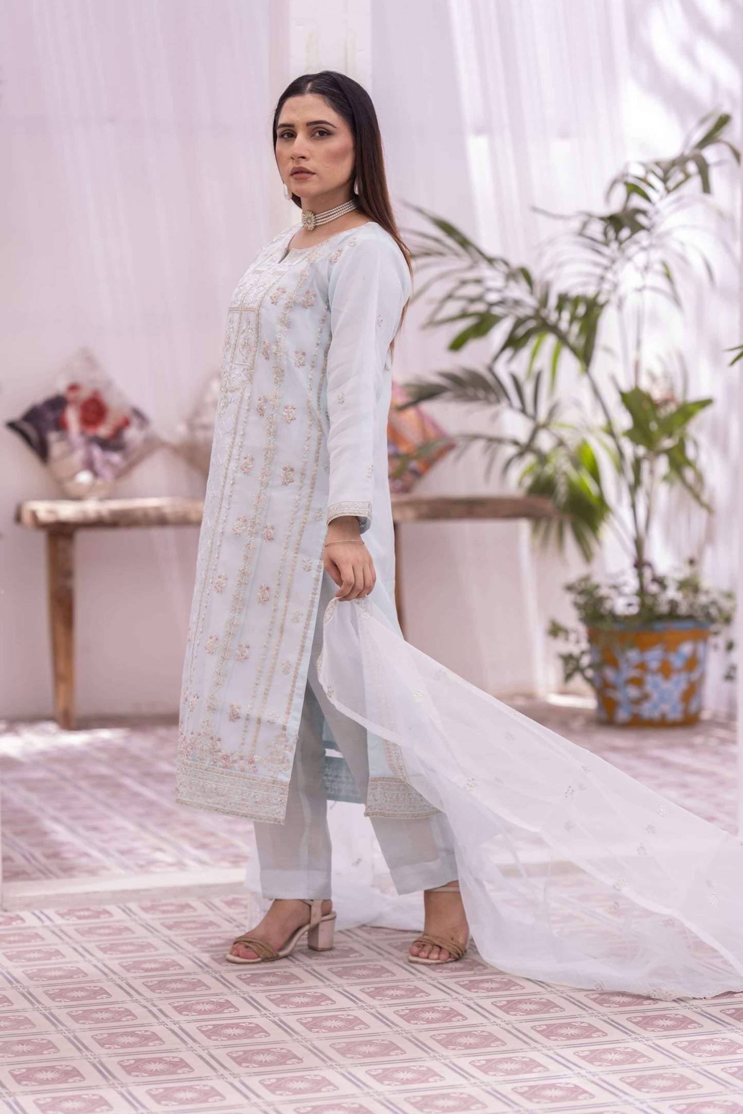 Woman in a light blue traditional shalwar kameez suit