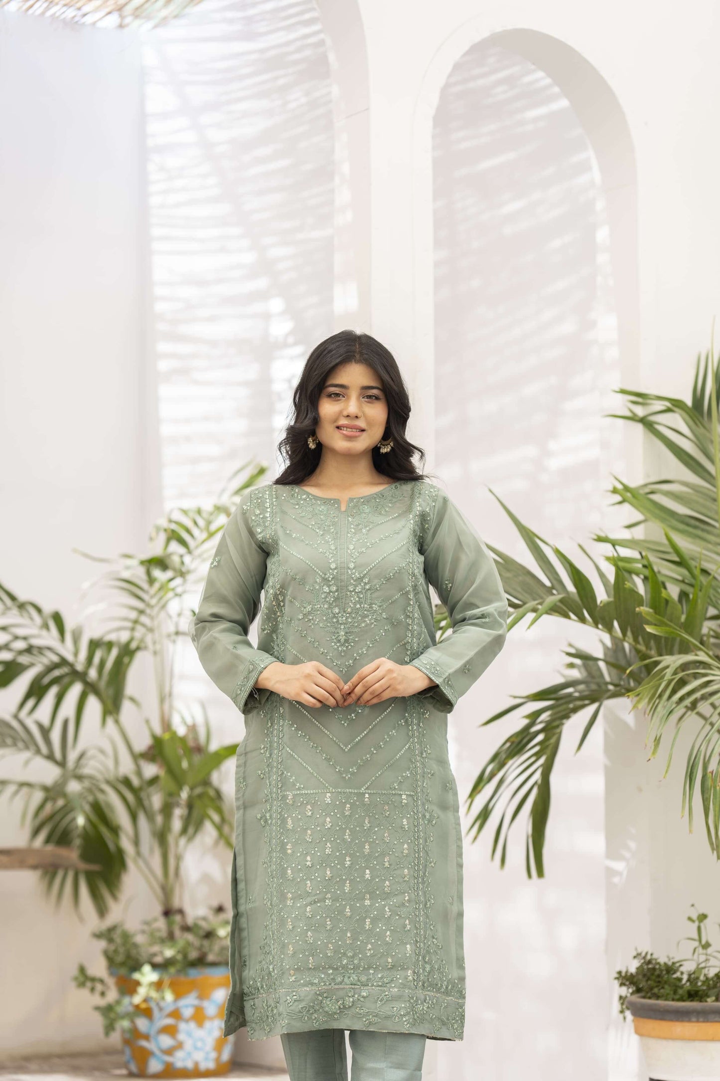 Woman wearing a light green kameez closeup.