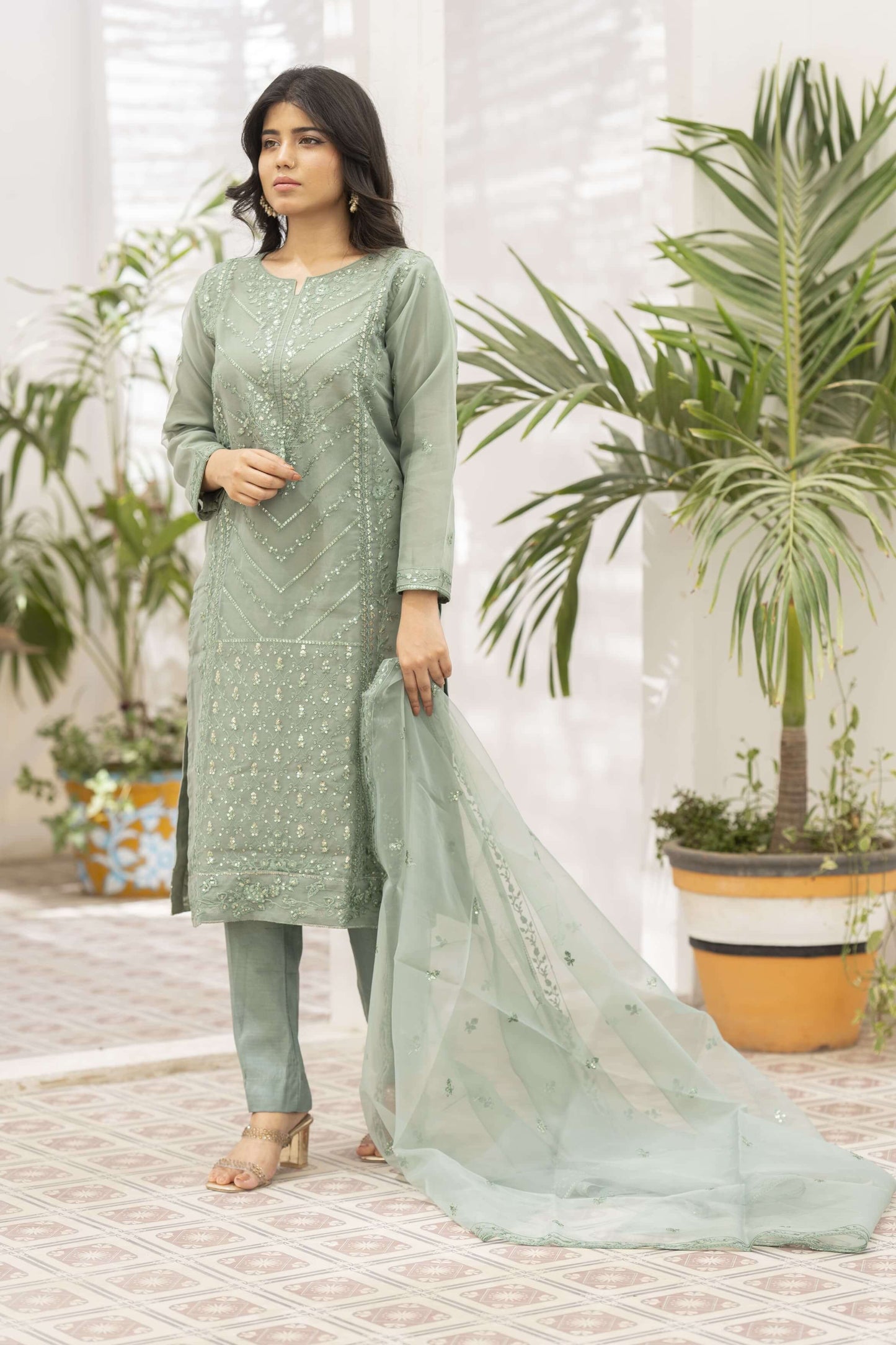 Woman wearing a light green traditional outfit with a dupatta