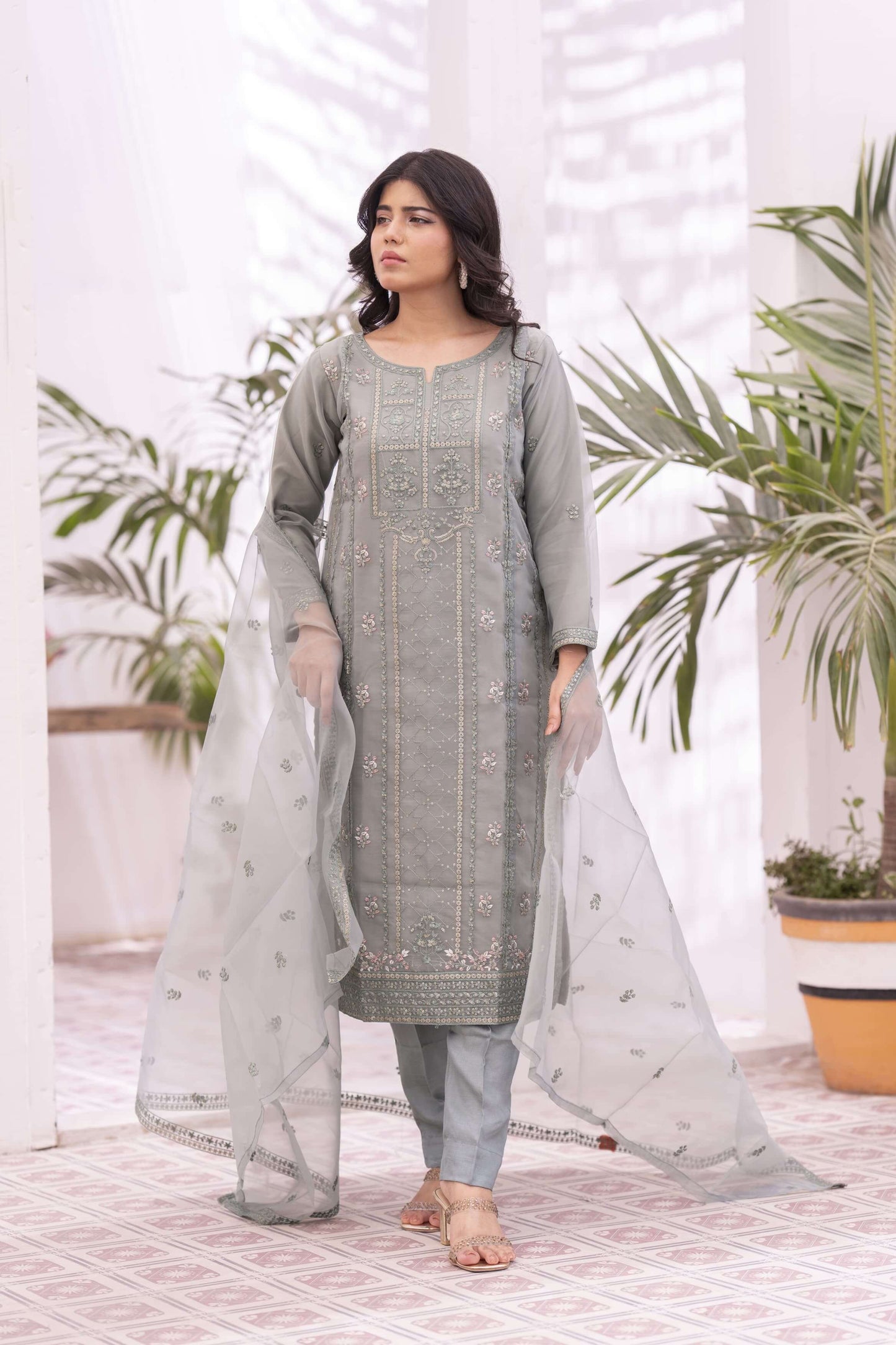 Woman wearing a light green traditional outfit with a light dupatta