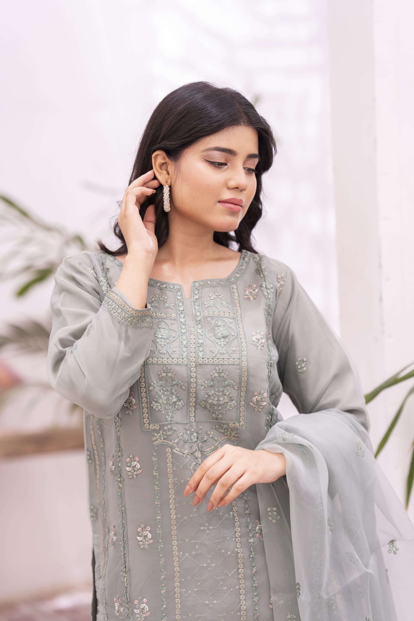 Closeup of woman wearing a light green embroidered traditional outfit