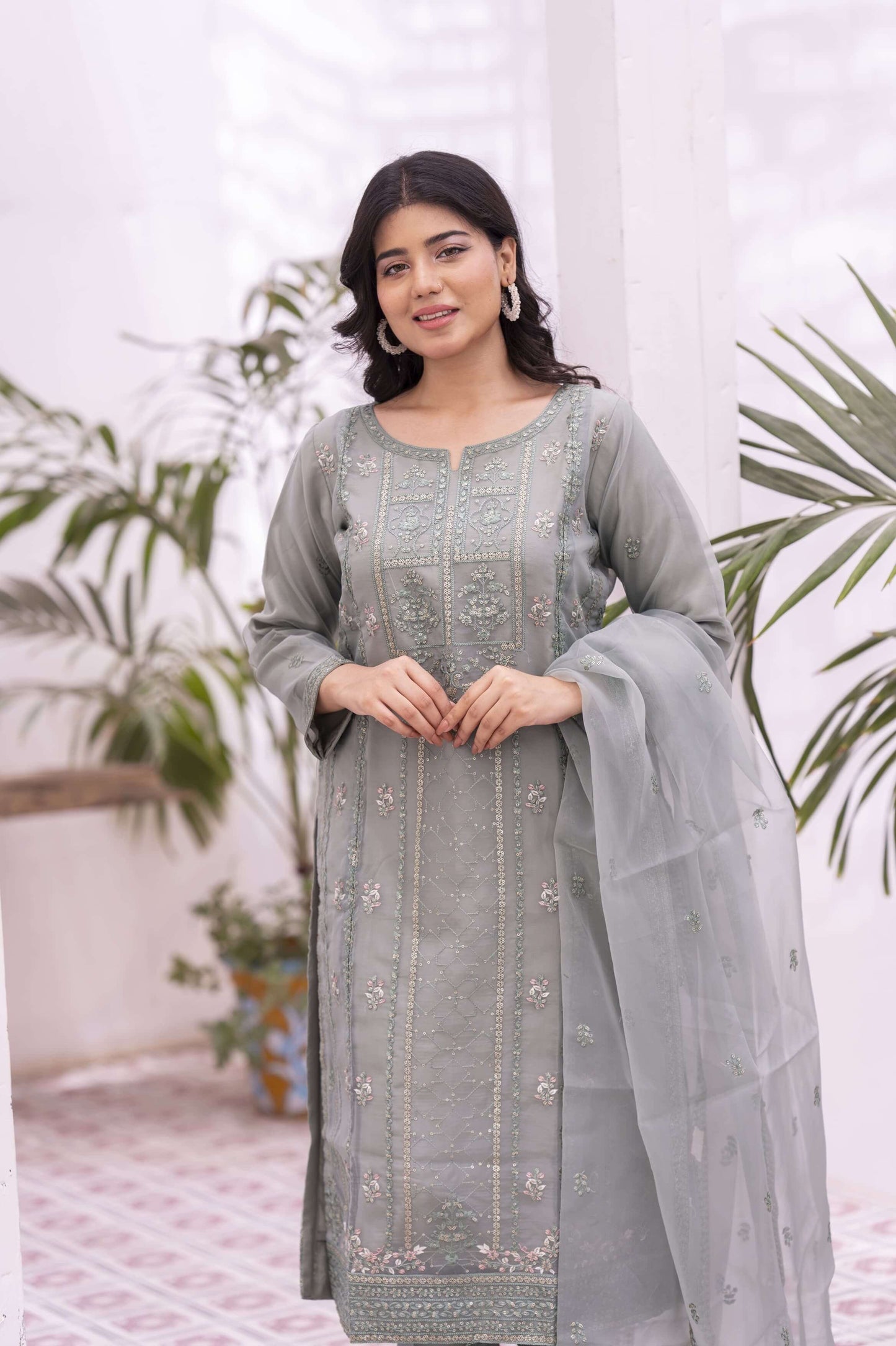 Woman wearing a green embroidered organza outfit with a dupatta