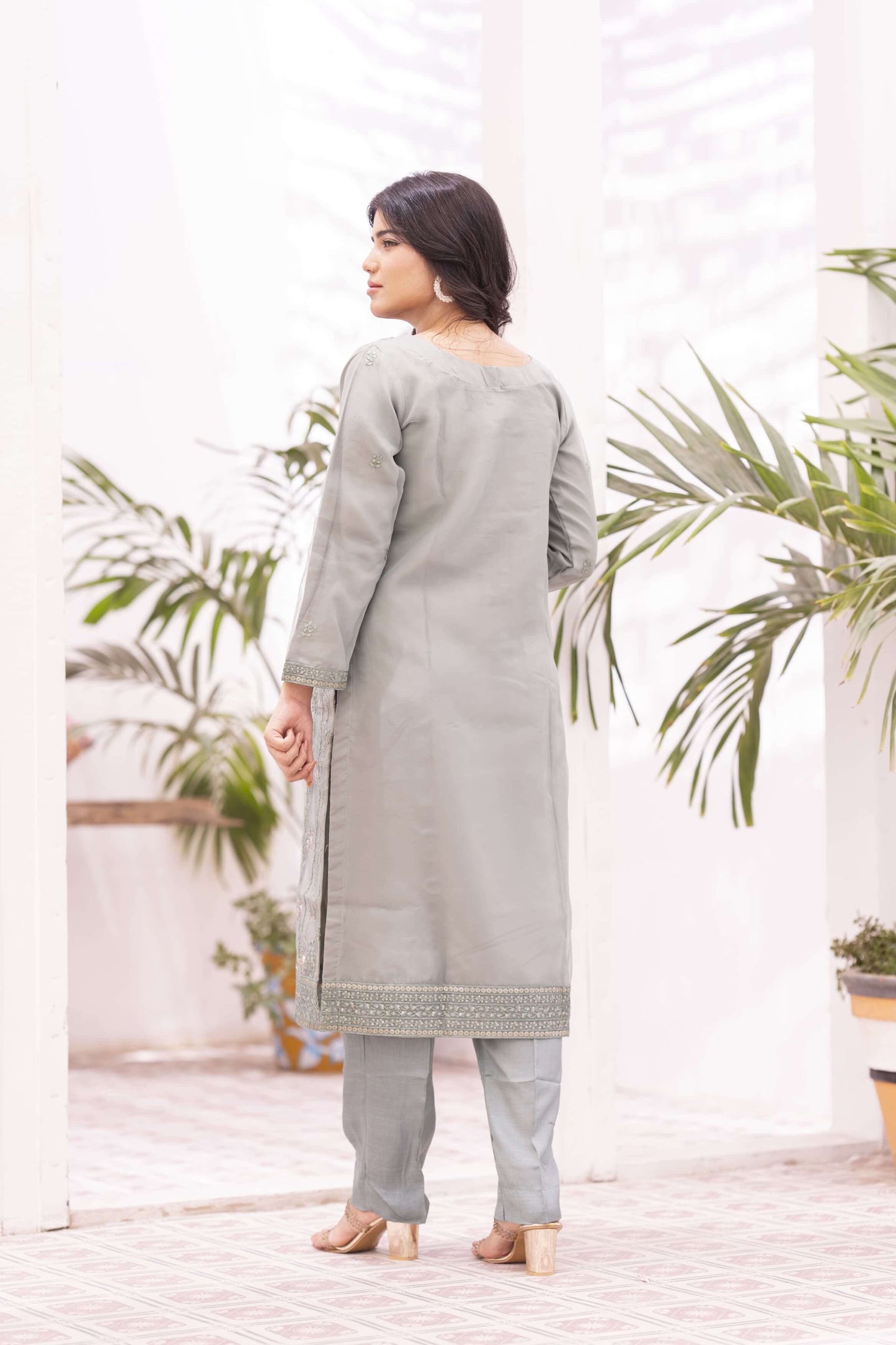 Woman wearing a light green traditional outfit back side