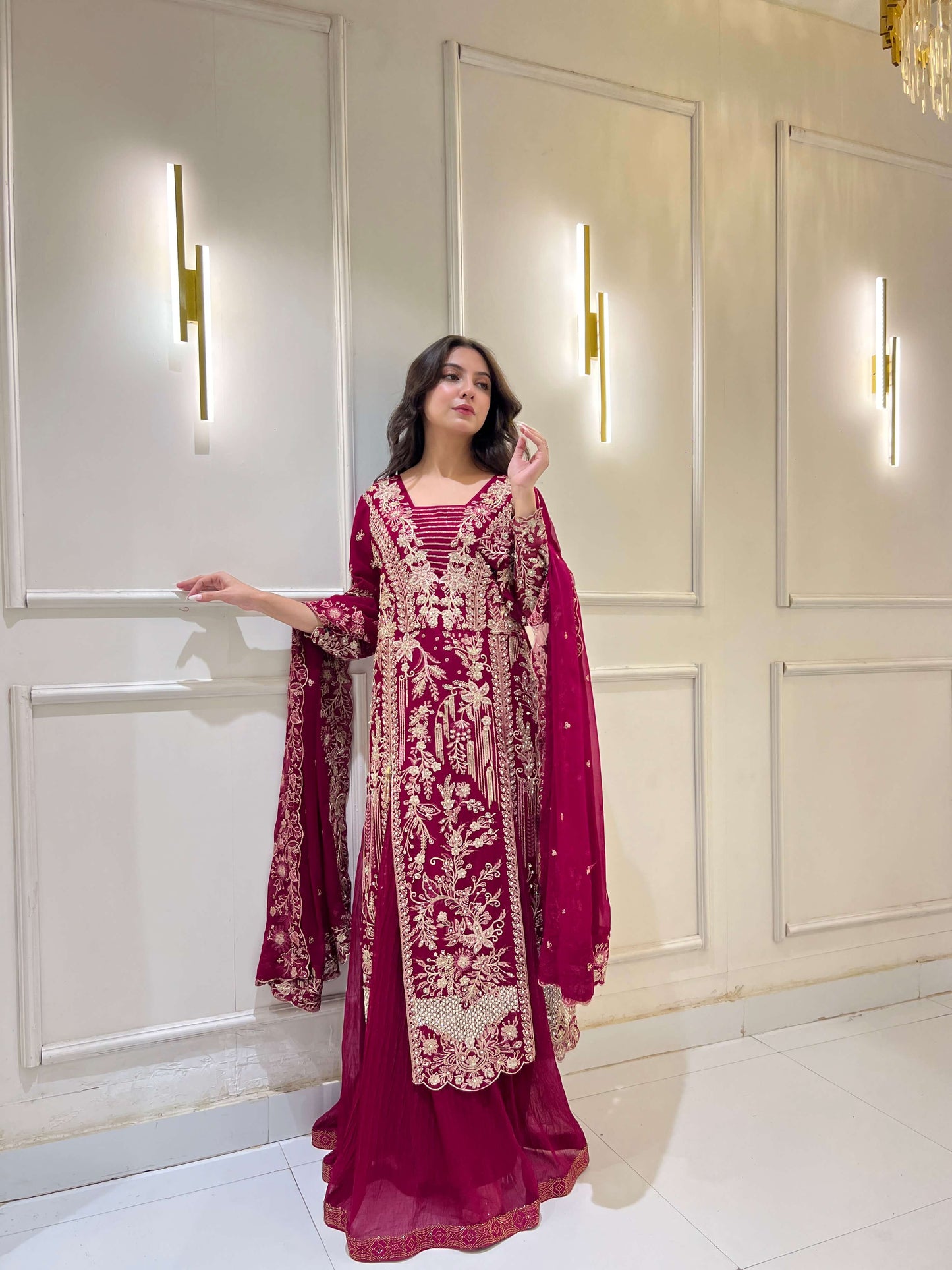 Model posing in magenta embroidered ijaar lehnga suit