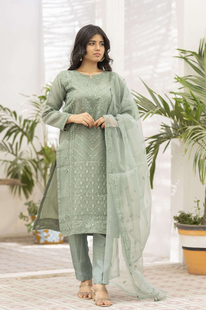 Woman wearing a light green traditional outfit with dupatta on shoulder