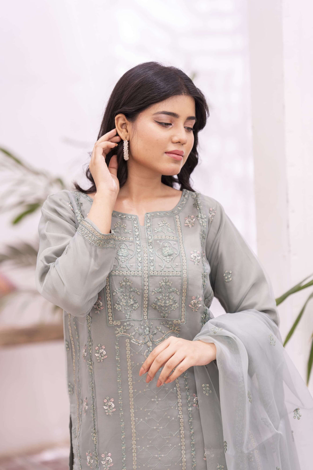 Closeup of woman wearing a light green embroidered traditional outfit