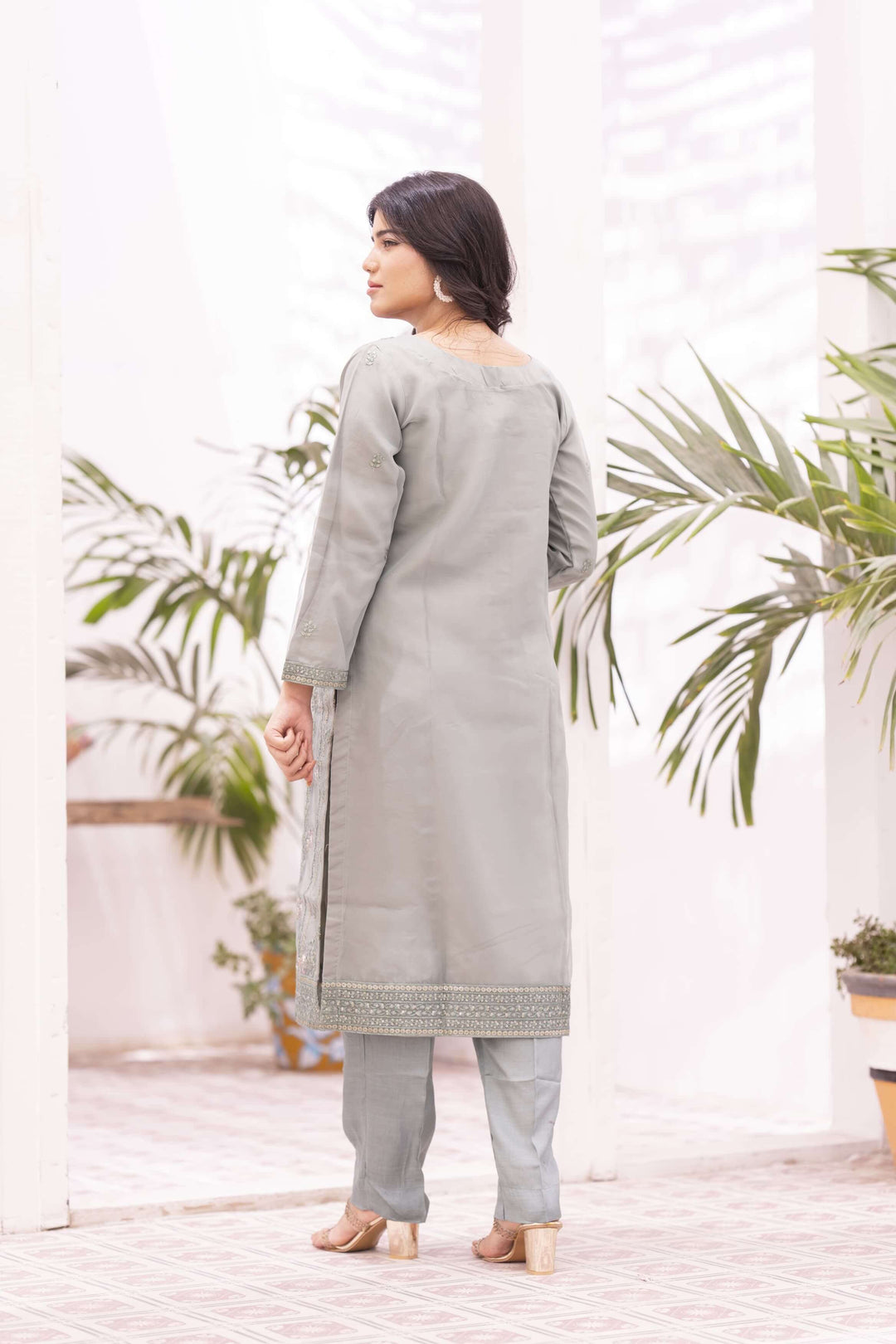 Woman wearing a light green traditional outfit back side