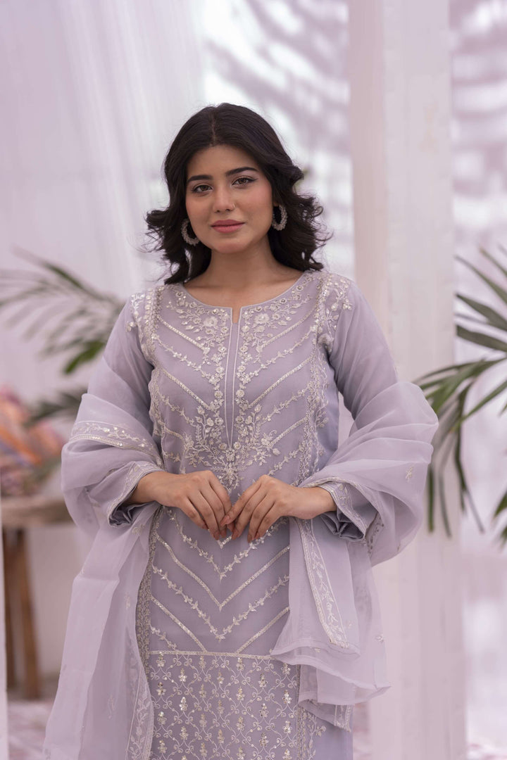 Woman wearing a light purple embroidered outfit with dupatta