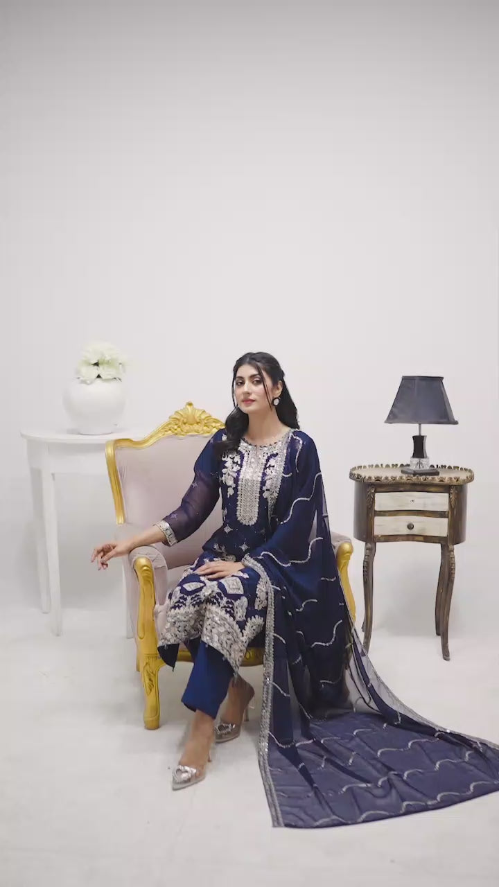 Model wearing navy blue chiffon 3-piece suit with white embroidery, showcasing flowy fabric, embroidery details, and elegant styling in motion.